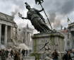 Falling statue on cracked pedestal with people running and collapsing buildings